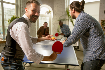 Image showing Young people playing table tennis in workplace, having fun