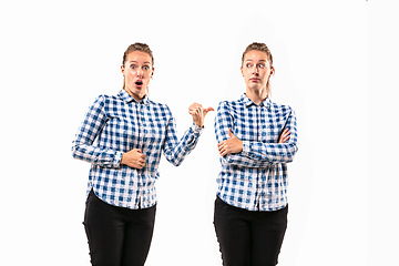 Image showing Young handsome woman arguing with herself on white studio background.