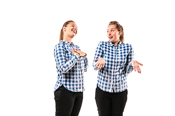 Image showing Young handsome woman arguing with herself on white studio background.