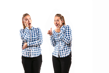 Image showing Young handsome woman arguing with herself on white studio background.