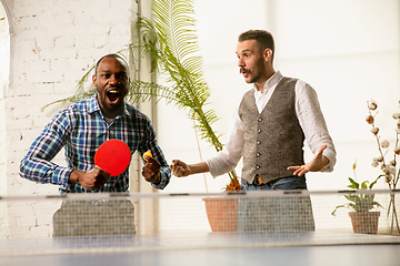 Image showing Young men playing table tennis in workplace, having fun