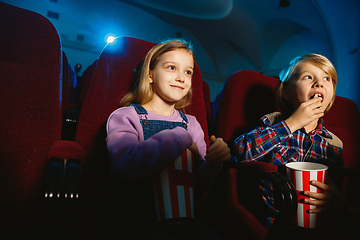 Image showing Little girl and boy watching a film at a movie theater