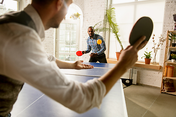 Image showing Young men playing table tennis in workplace, having fun