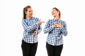 Image showing Young handsome woman arguing with herself on white studio background.