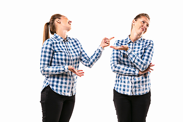 Image showing Young handsome woman arguing with herself on white studio background.