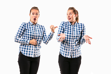 Image showing Young handsome woman arguing with herself on white studio background.