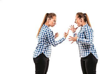 Image showing Young handsome woman arguing with herself on white studio background.