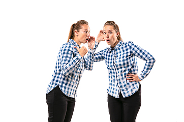 Image showing Young handsome woman arguing with herself on white studio background.