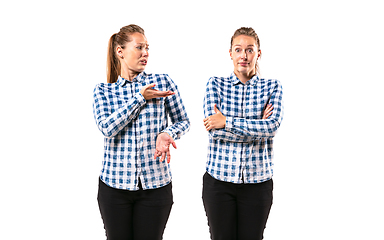 Image showing Young handsome woman arguing with herself on white studio background.