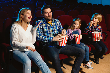 Image showing Young caucasian family watching a film at a movie theater