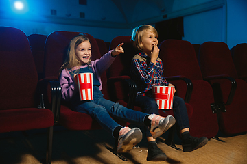 Image showing Little girl and boy watching a film at a movie theater
