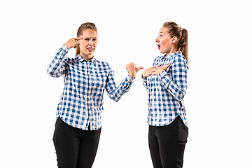 Image showing Young handsome woman arguing with herself on white studio background.