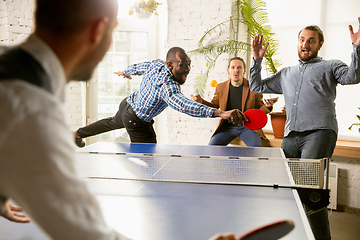 Image showing Young people playing table tennis in workplace, having fun