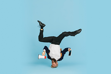 Image showing Businessman having fun dancing break dance on blue background at work