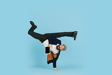 Image showing Businessman having fun dancing break dance on blue background at work