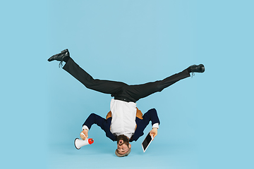 Image showing Businessman having fun dancing break dance on blue background at work