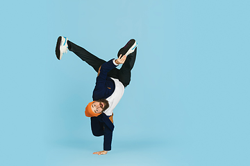 Image showing Businessman having fun dancing break dance on blue background at work