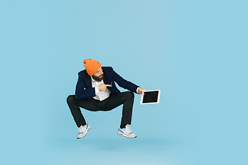 Image showing Businessman having fun dancing break dance on blue background at work