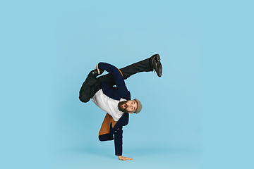 Image showing Businessman having fun dancing break dance on blue background at work