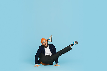 Image showing Businessman having fun dancing break dance on blue background at work