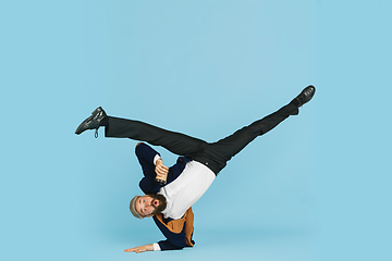 Image showing Businessman having fun dancing break dance on blue background at work