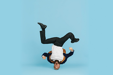 Image showing Businessman having fun dancing break dance on blue background at work