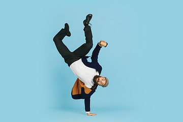 Image showing Businessman having fun dancing break dance on blue background at work