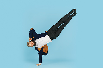 Image showing Businessman having fun dancing break dance on blue background at work