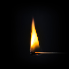 Image showing match stick flame in front of a black background