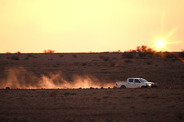 Image showing car on a dusty unsealed road in sunset light mood