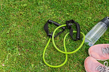 Image showing Fit tube and sneakers on the green grass background