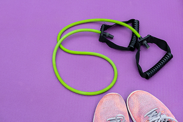 Image showing Sneakers, fit tube and a purple fitness mat. Sport concept