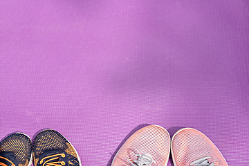 Image showing Sneakers and a purple fitness mat. Sport concept