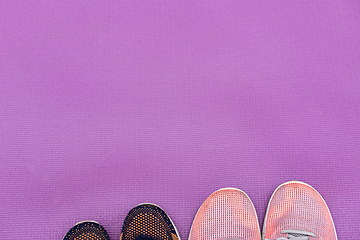 Image showing Sneakers and a purple fitness mat. Sport concept