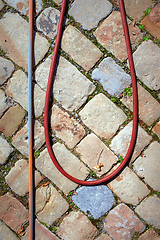 Image showing water hose on a cobble stone floor