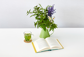 Image showing herbal tea, book and flowers in jug on table