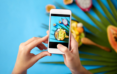 Image showing hands taking photo of exotic fruits on smartphone