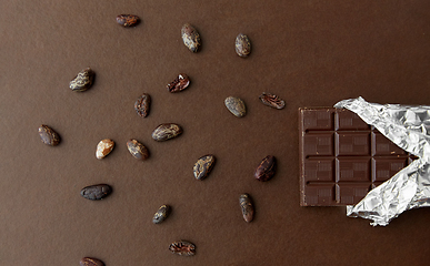 Image showing dark chocolate bar in foil wrapper and cocoa beans