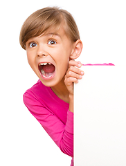 Image showing Little girl is looking out from the blank banner