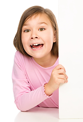 Image showing Little girl is looking from out blank board