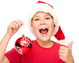 Image showing Little girl in santa hat is showing thumb up sign