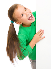 Image showing Little girl is looking from out blank board