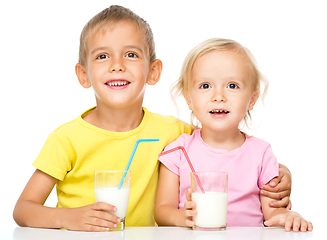 Image showing Cute little girl and boy are drinking milk