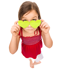 Image showing Little girl is holding hearts over her eyes