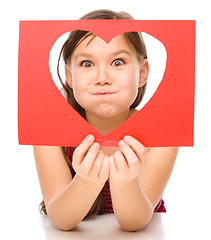 Image showing Little girl is looking through heart template