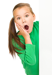 Image showing Little girl is looking out from the blank banner