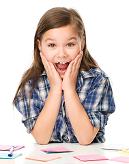 Image showing Girl is writing on color stickers using pen