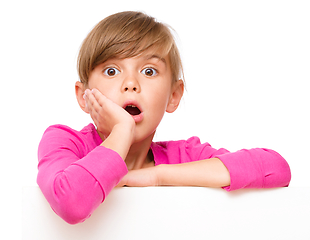 Image showing Little girl is looking out from the blank banner