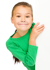 Image showing Little girl is looking from out blank board