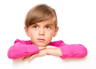 Image showing Little girl is looking out from the blank banner